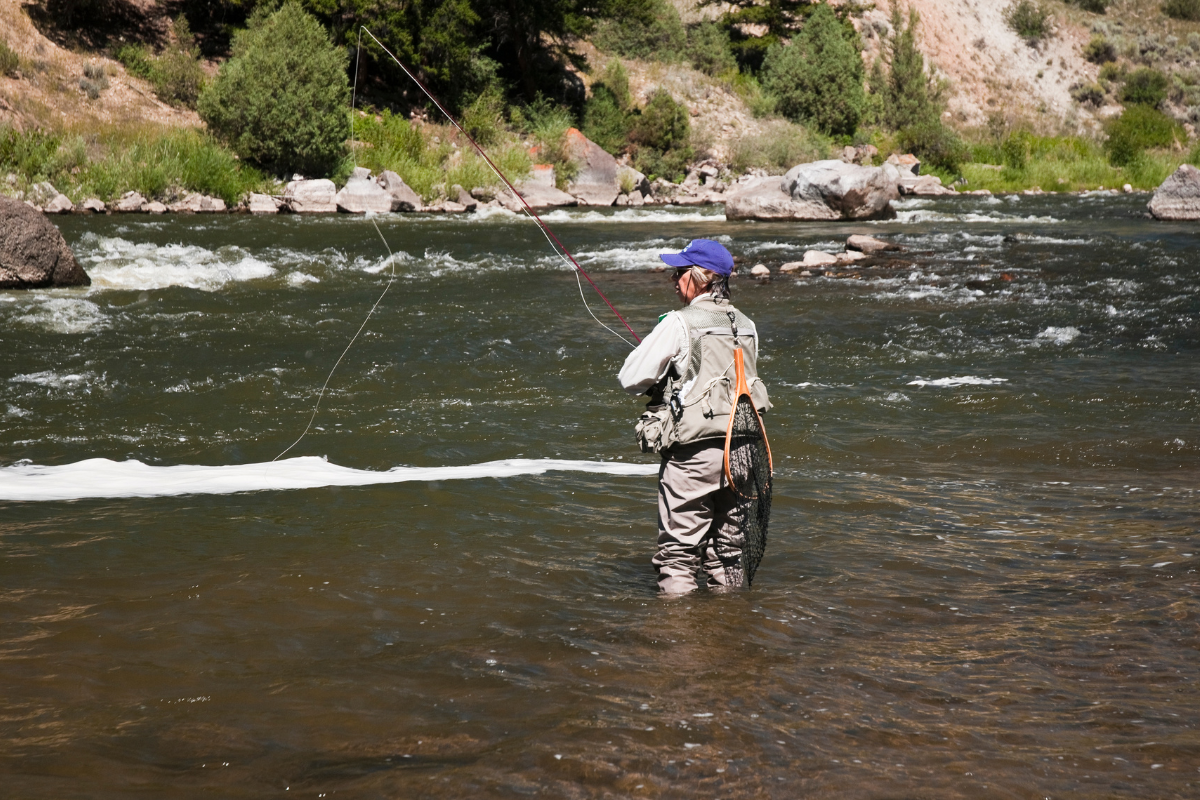 a man standing next to a body of water