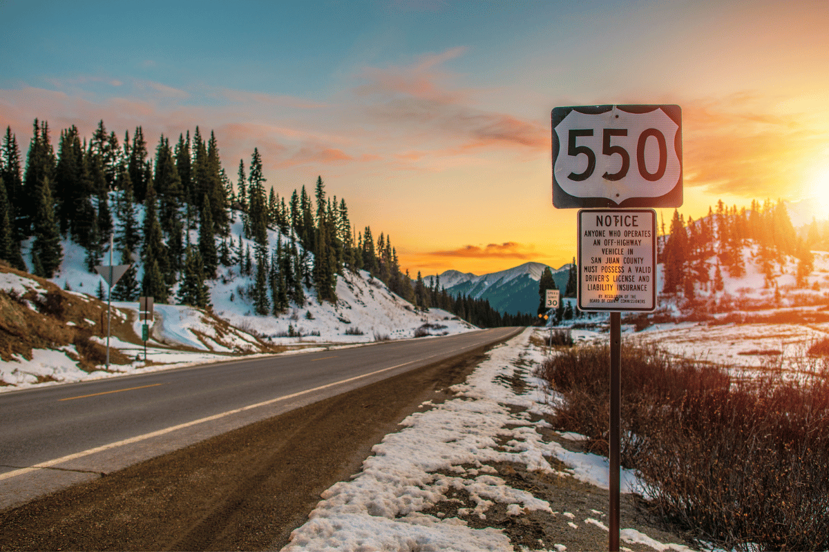 a sign on the side of a snow covered road