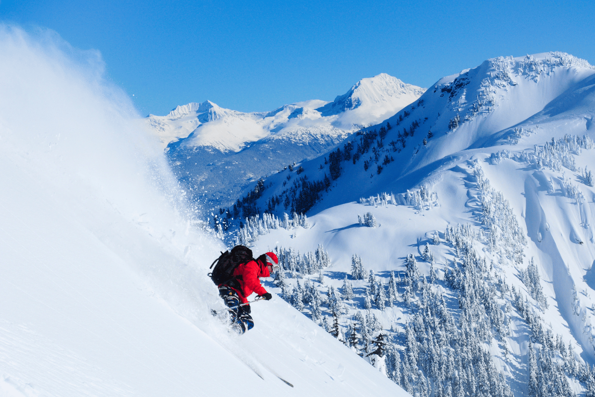 a man riding skis down a snow covered mountain