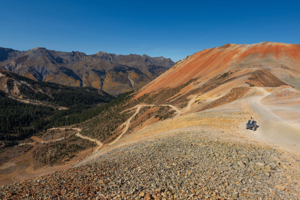 the top of a pass in the rocky mountains with a ATV on top