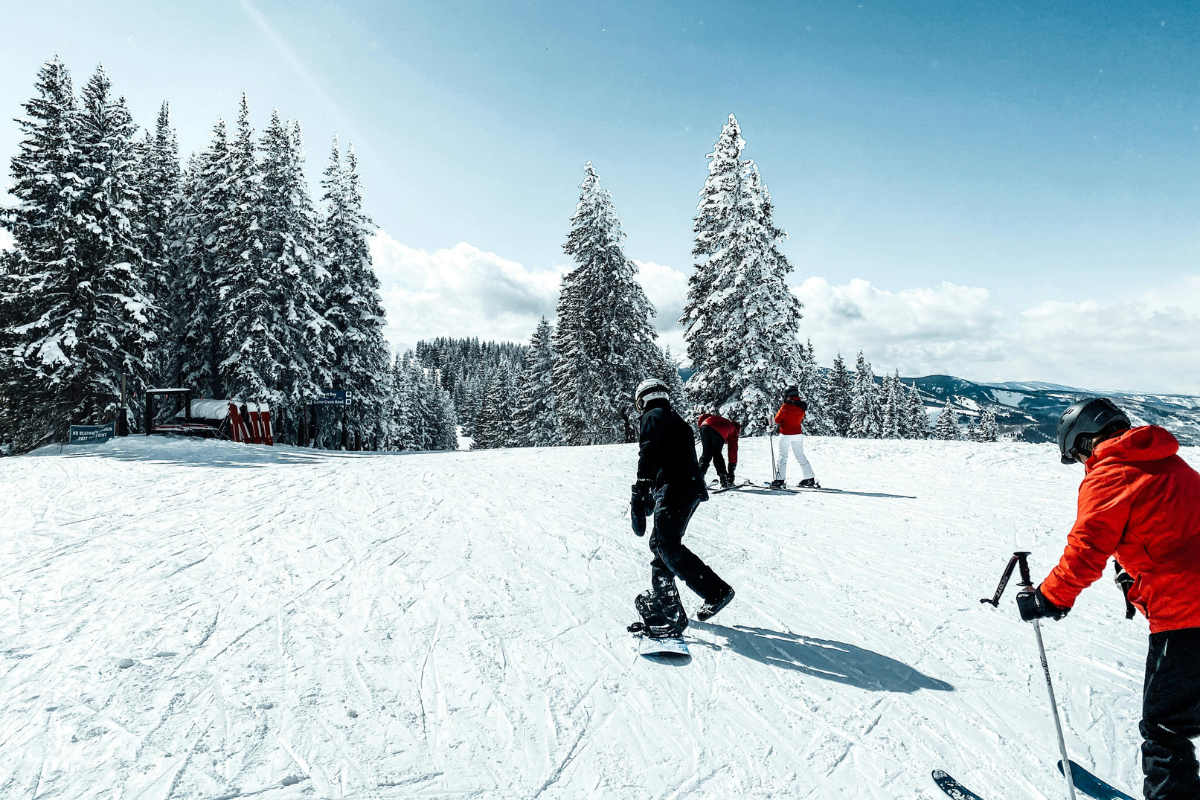 a group of people riding skis on top of a snow covered slope